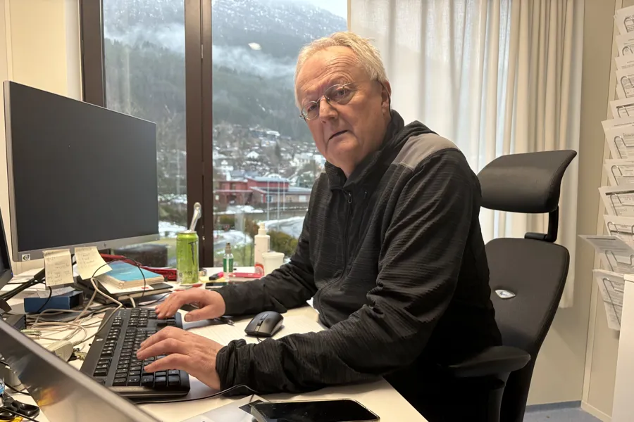 en mann foran pc og skrivebord