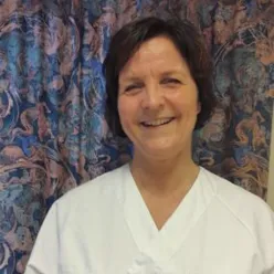 En kvinne som smiler til kameraet