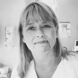 En kvinne som smiler til kameraet