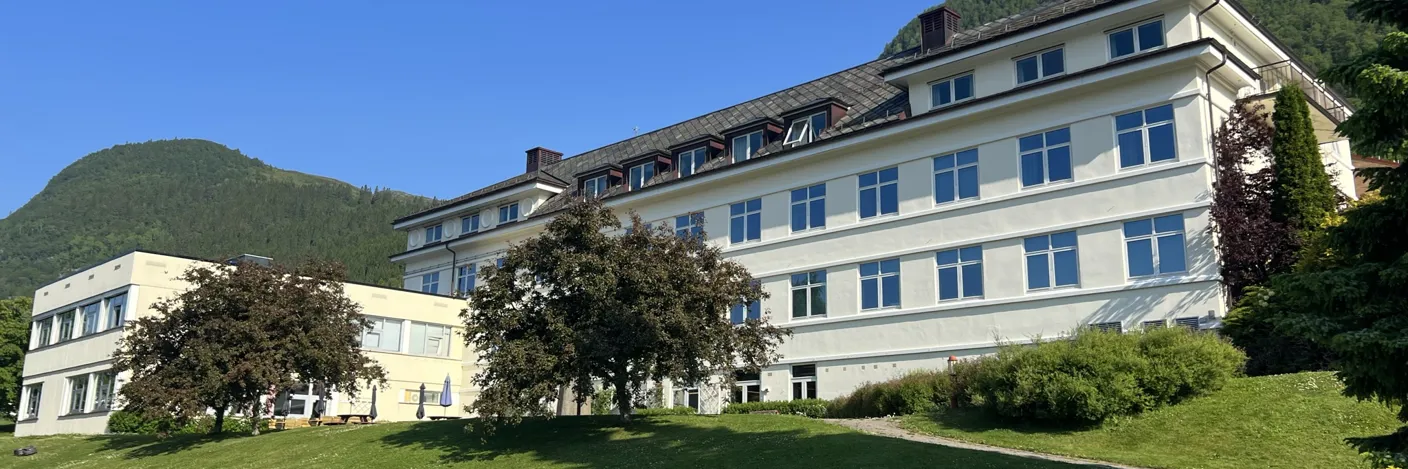 En stor sykehusbygning med en plen foran seg