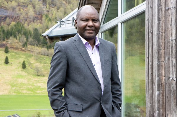 En mann i dress står utenfor en bygning