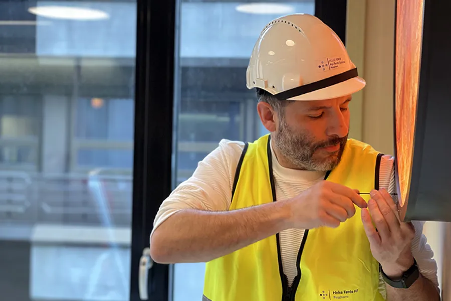 Ein kunstnar som monterer eit kunstverk