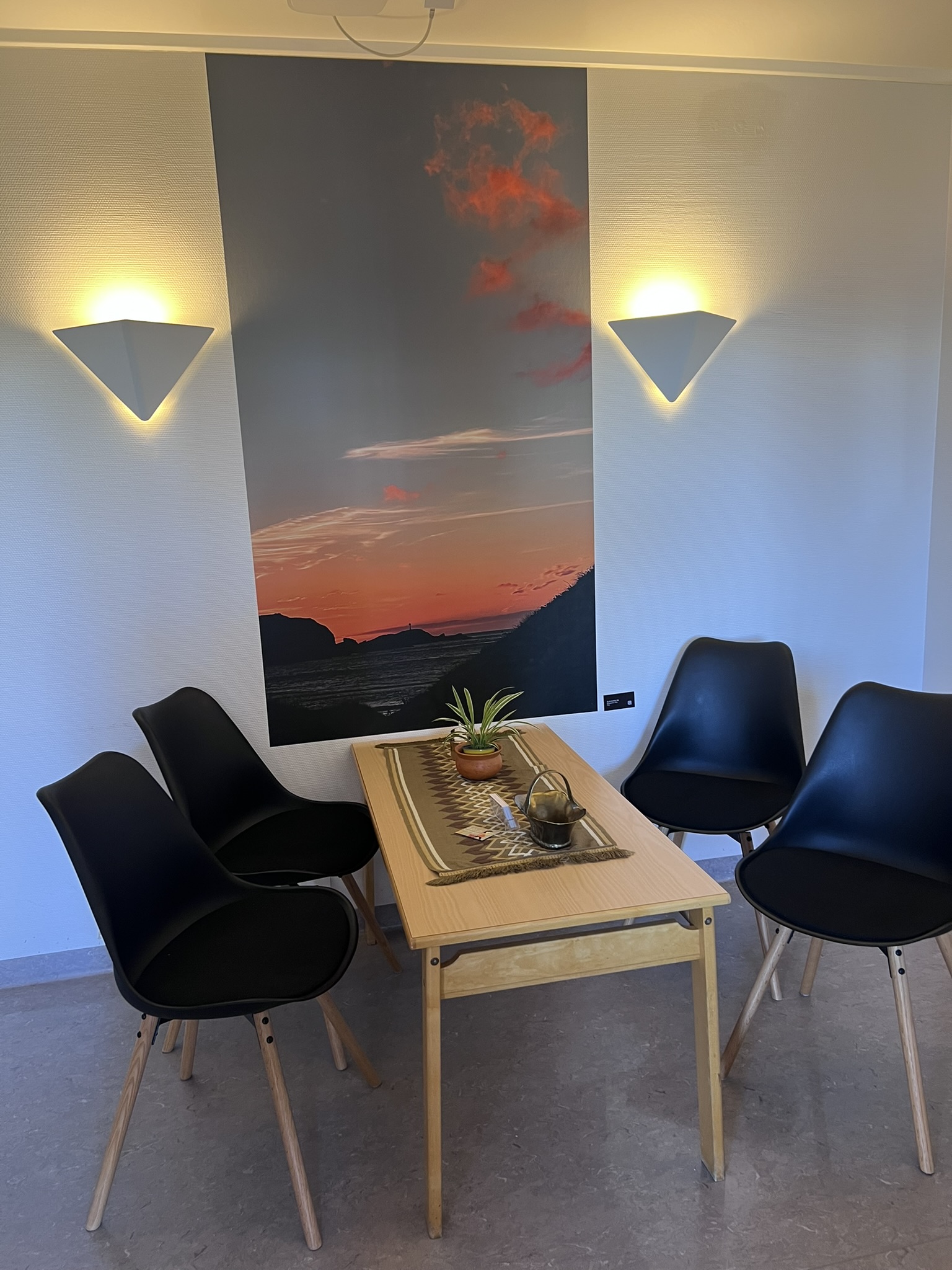 Eit bilde som viser solnedgang ved havet i eit venterom på barselavdelinga