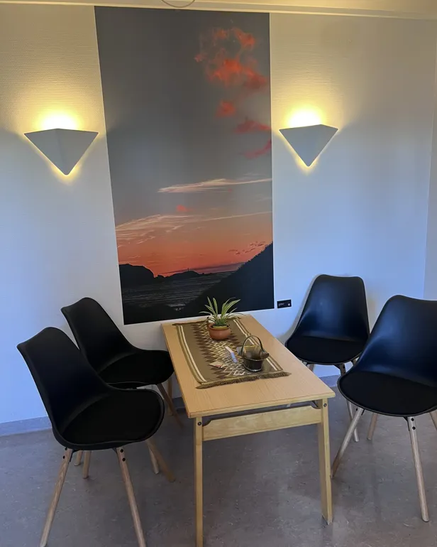 Eit bilde som viser solnedgang ved havet i eit venterom på barselavdelinga