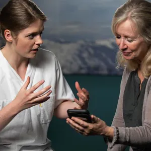 Two persons looking at a cell phone