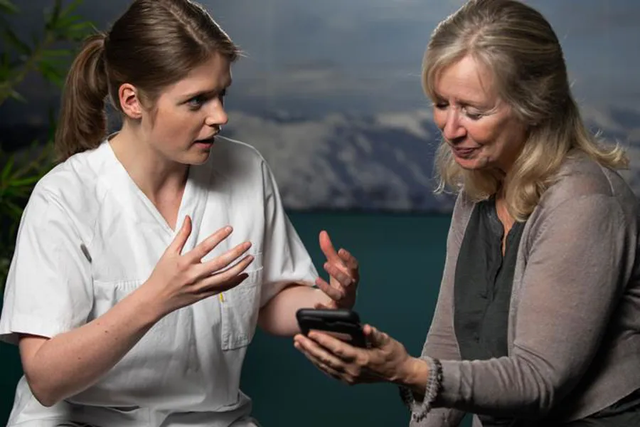 To personar som ser på ein mobiltelefon
