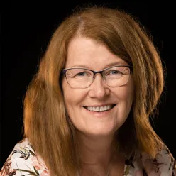 En kvinne med langt hår som smiler