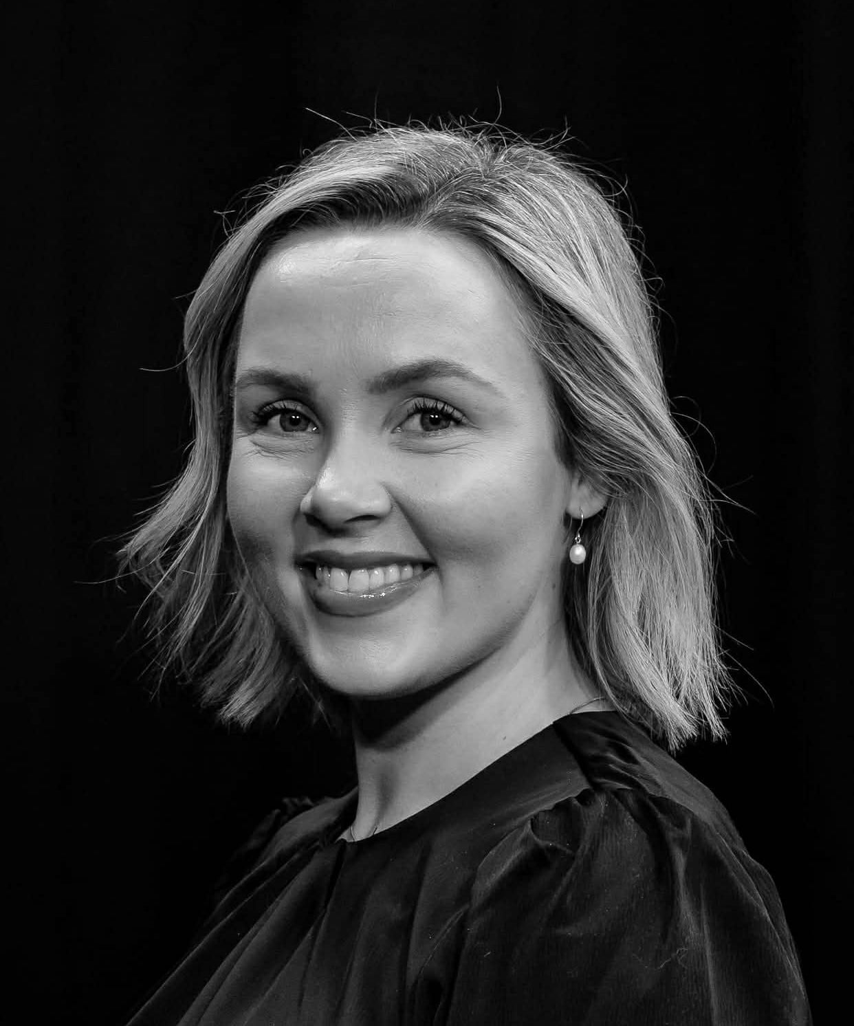En kvinne som smiler til kameraet