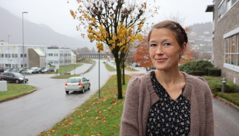 Ei kvinne som står på fortauet