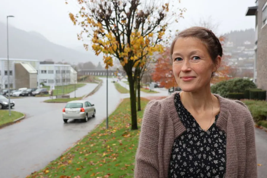 Ei kvinne som står på fortauet