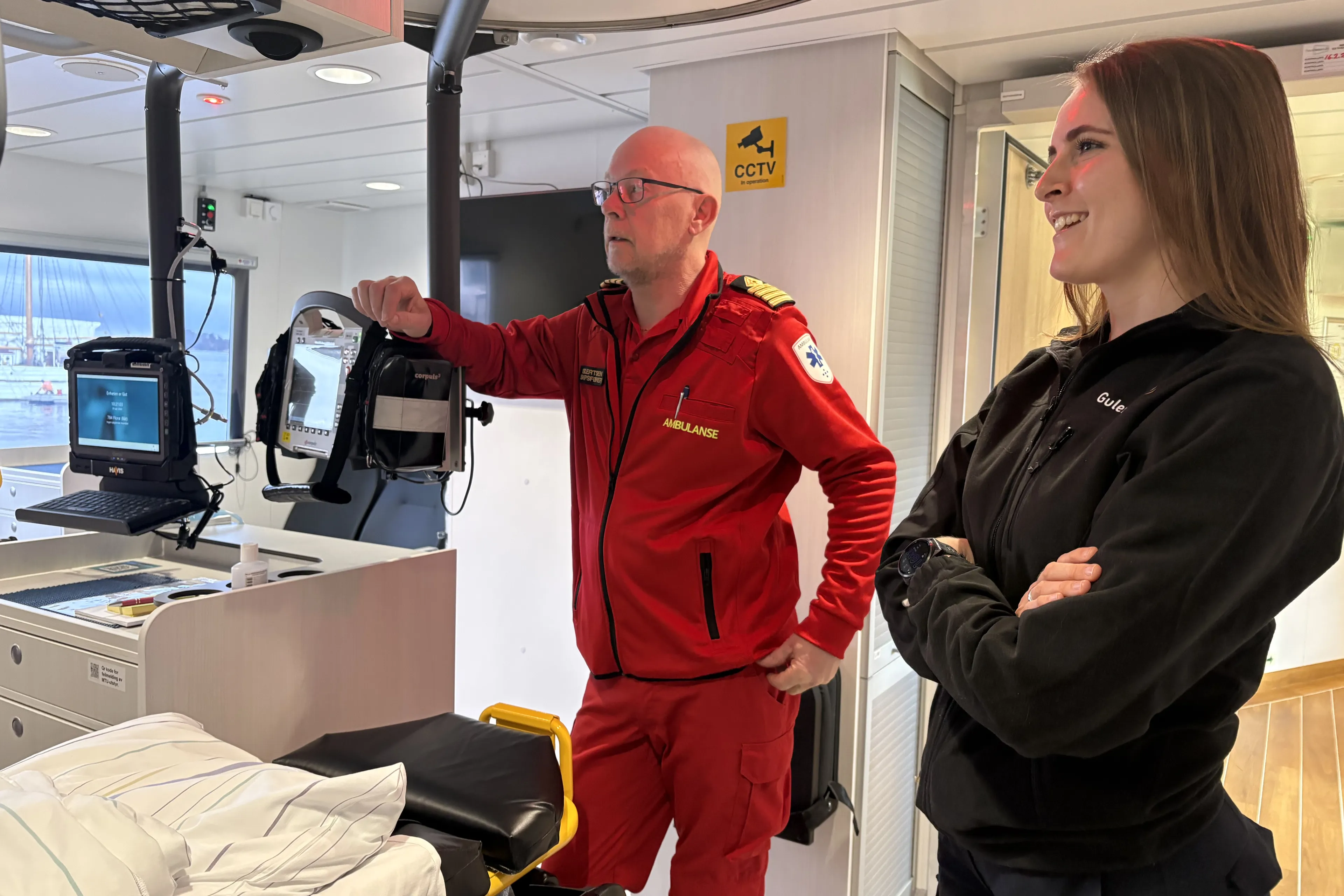Ein mann og ei kvinne i uniformar ombord i ambulansebåten