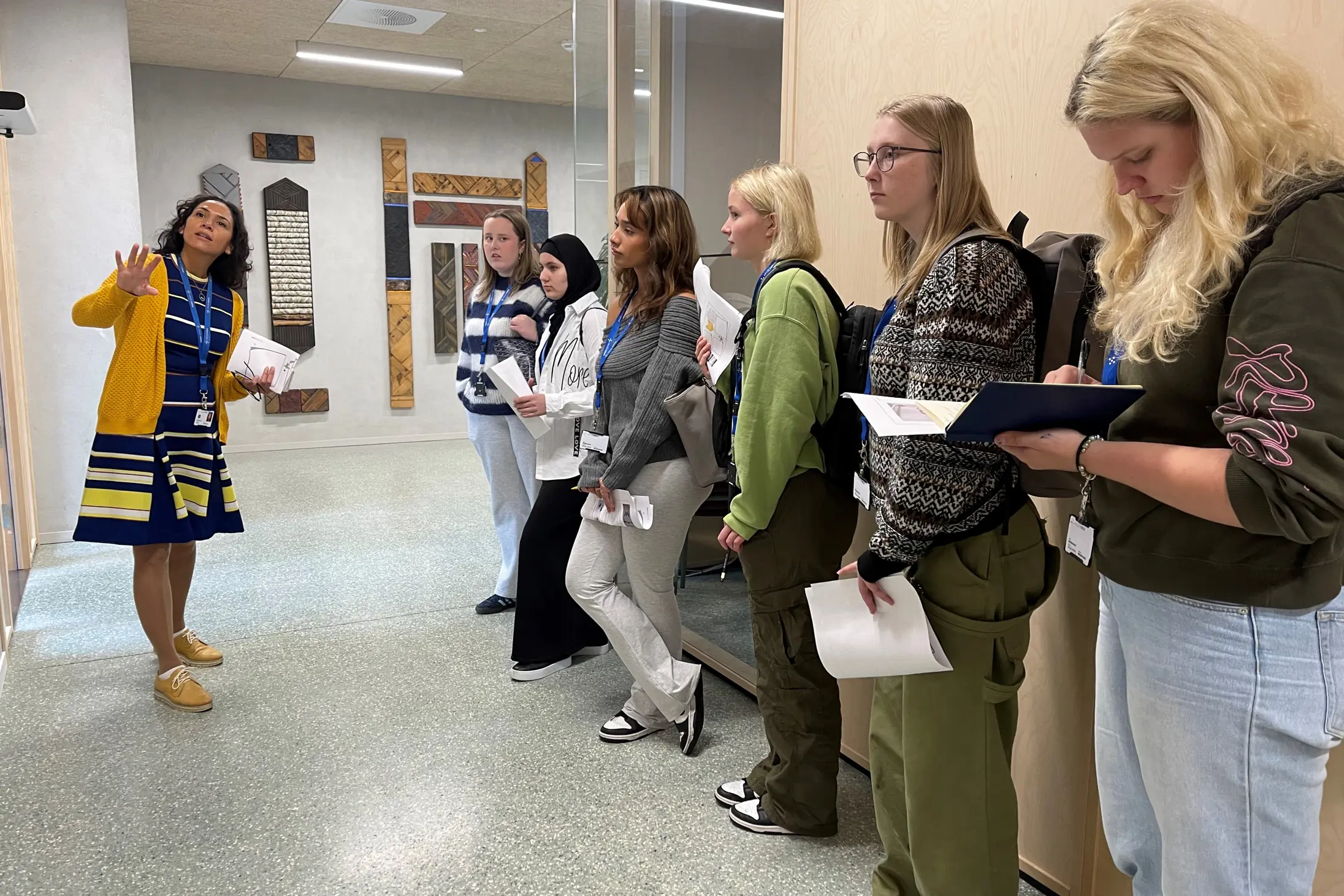 Ei gruppe som står i og ser på eit kunstverk