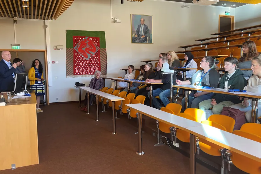 Ei gruppe menneske som sit i eit rom