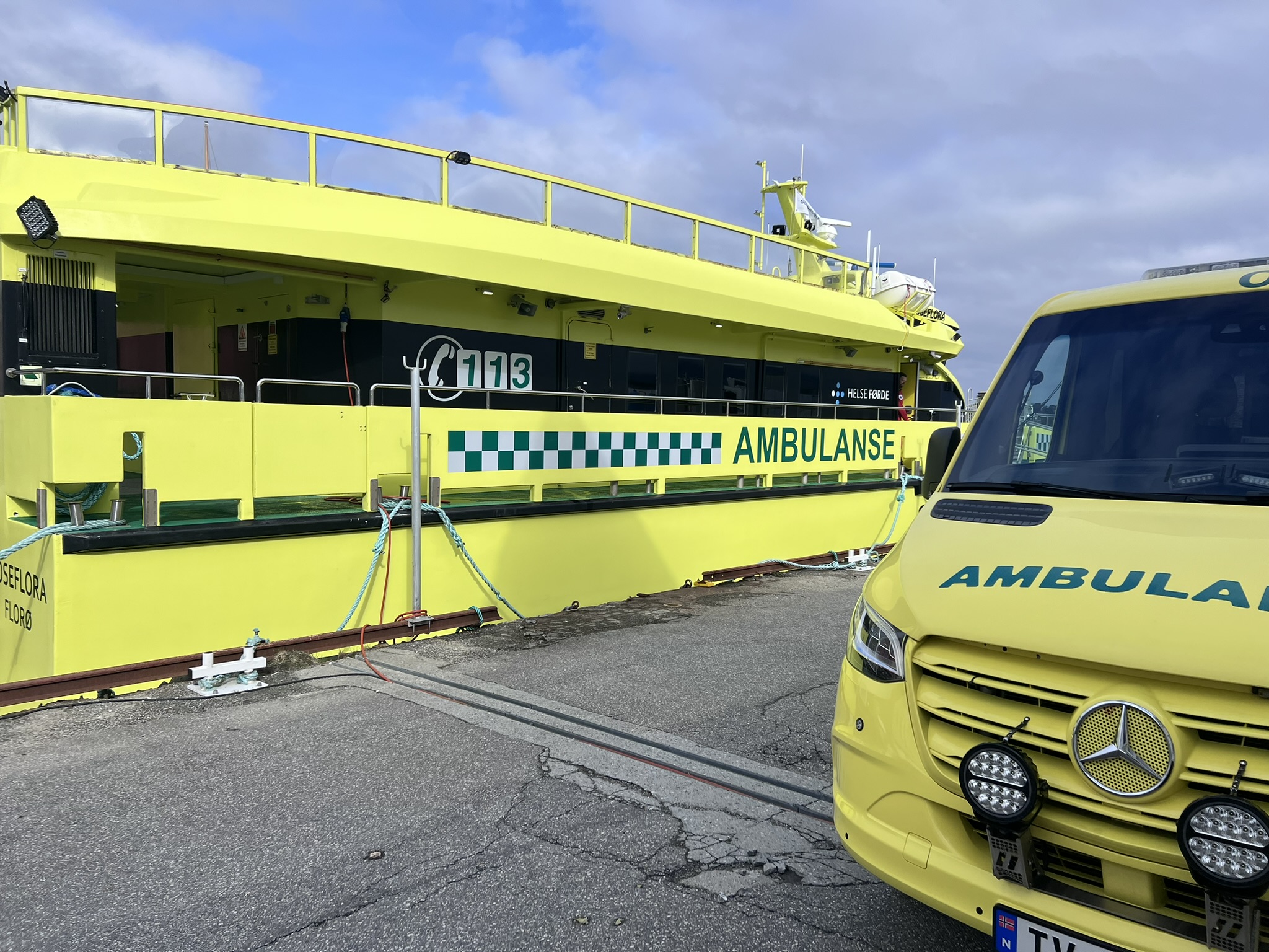 Ambulansebåt ved kai og ambulansebil på land