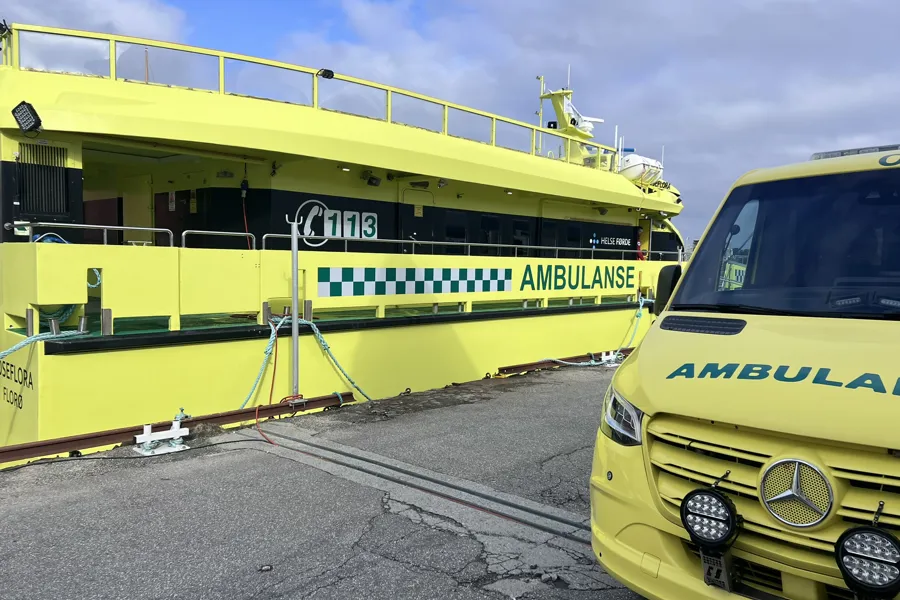 Ambulansebåt ved kai og ambulansebil på land