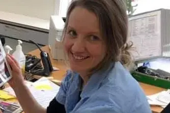 Bilde av smilende kvinne ved skrivebord