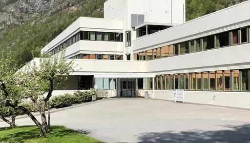 Institusjon med blomstrande frukttre og flagg framfor
