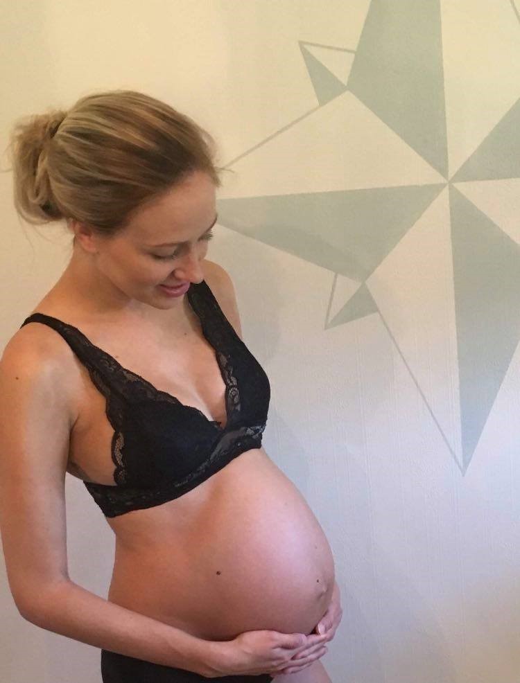 Ei gravid kvinne som viser fram magen sin