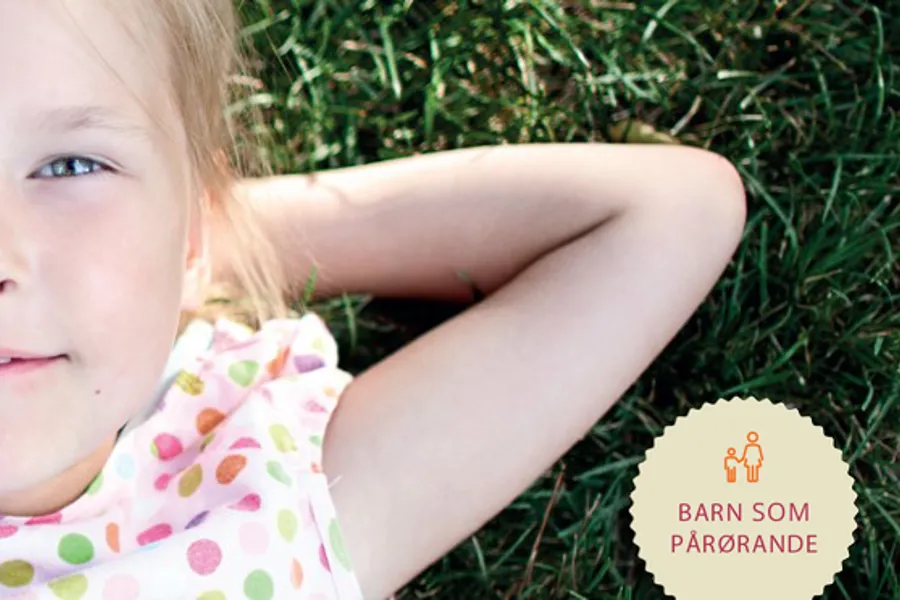 En jente som ligger i gresset