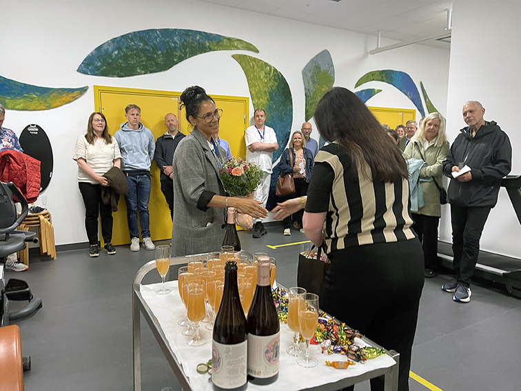 En gruppe mennesker som står rundt et bord med vinflasker