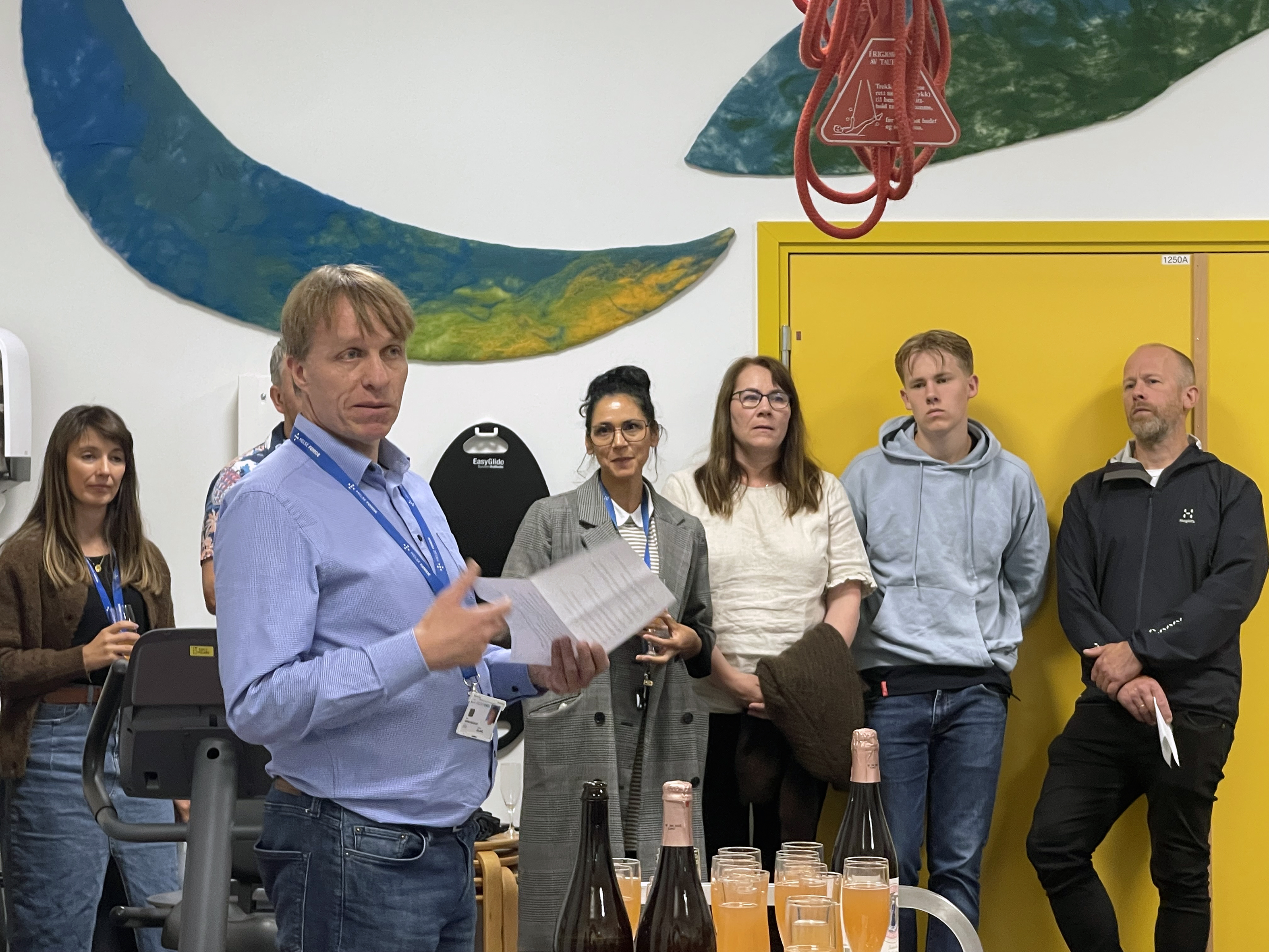 En gruppe mennesker som står foran et bord med drinker