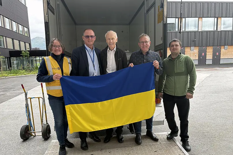 Ei gruppe menneske som held eit flagg