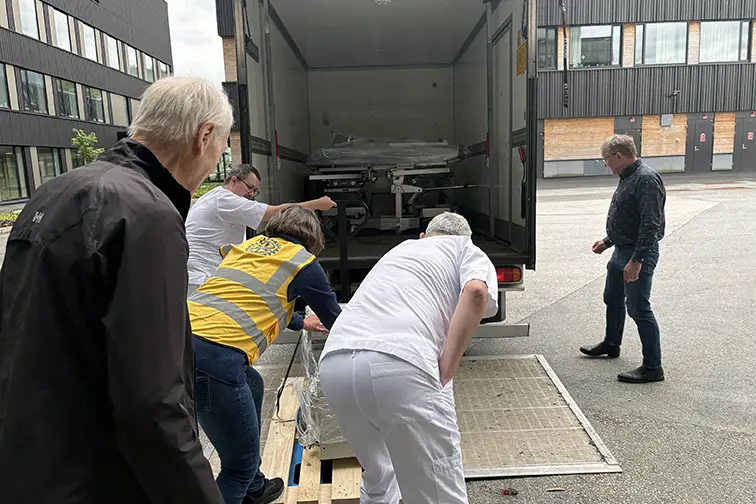 Ei gruppe menneske som lastar ein lastebil
