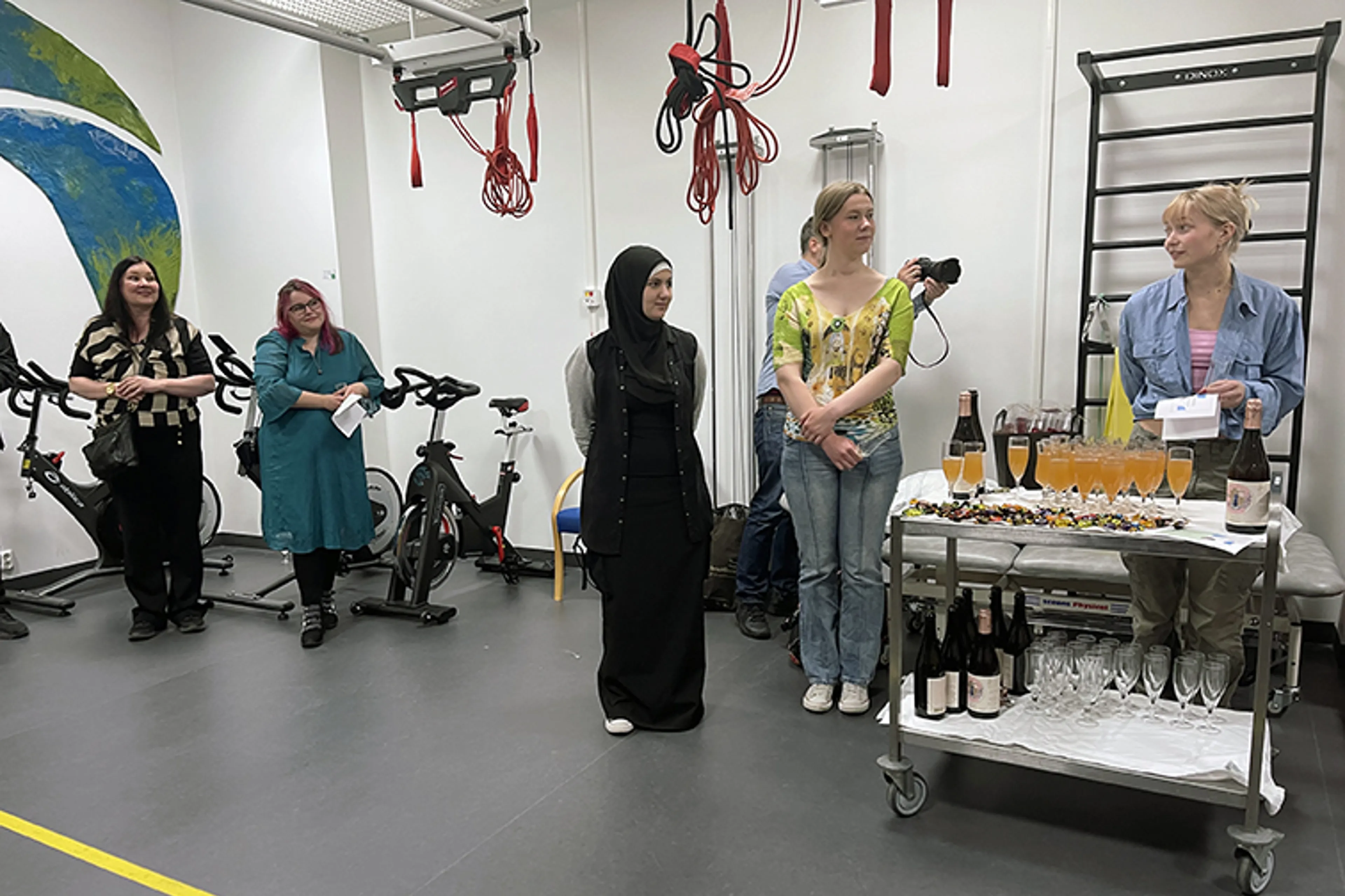 Ei gruppe mennesker som står i eit rom med bord med mat og drikke