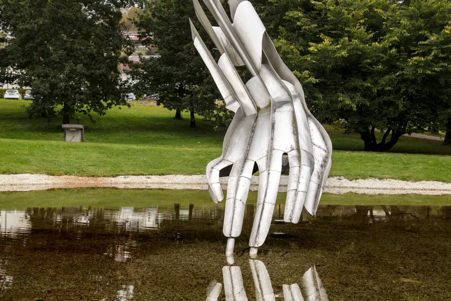 kunstinstallasjon av ei hand i ein dam i sjukehusparken