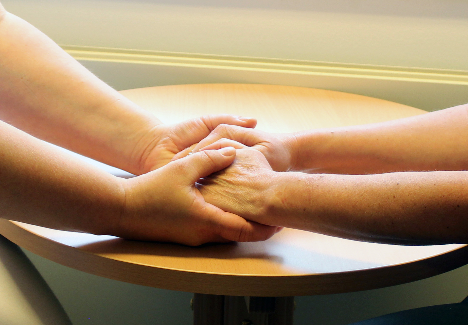 Nærbilde av to personar som held hender