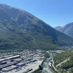 naturbilde over Årdal med grøne fjellsider og blå himmel