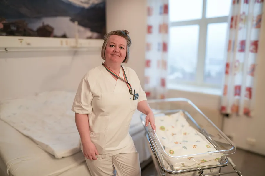 Ei kvinneleg jordmor som står inne på eit barselrom ved Nordfjord sjukehus
