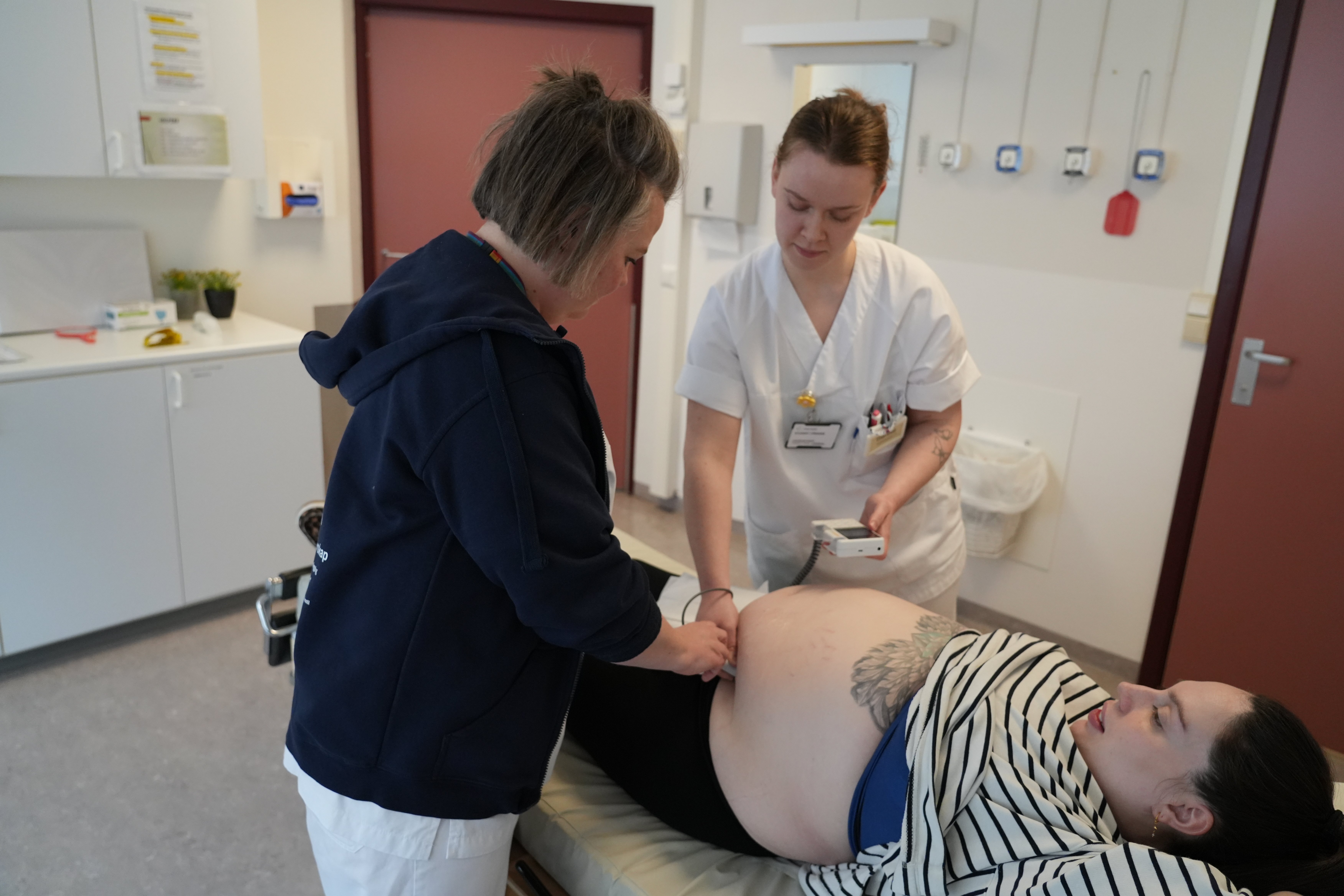Ei jordmor og ein jordmorstudent undersøker ei gravid kvinne