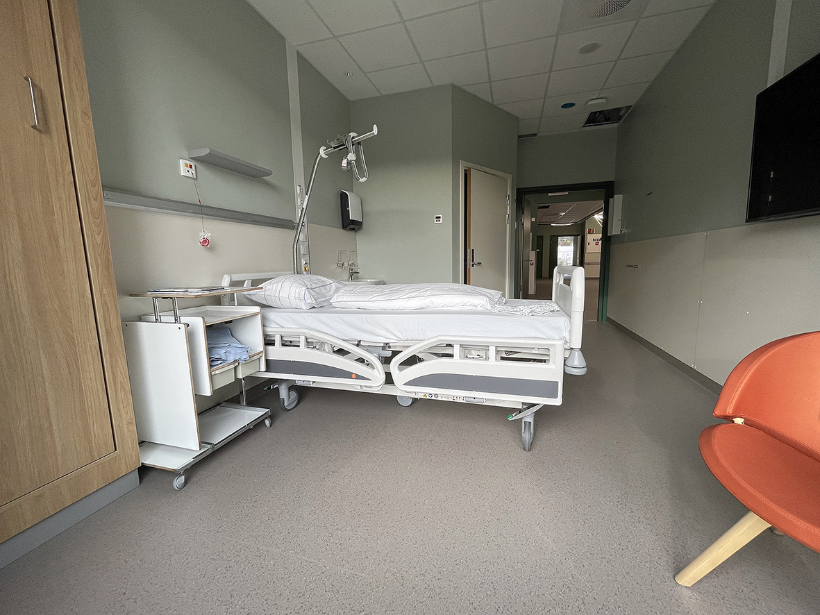 Eit sjukehusrom med ei seng og ein stol