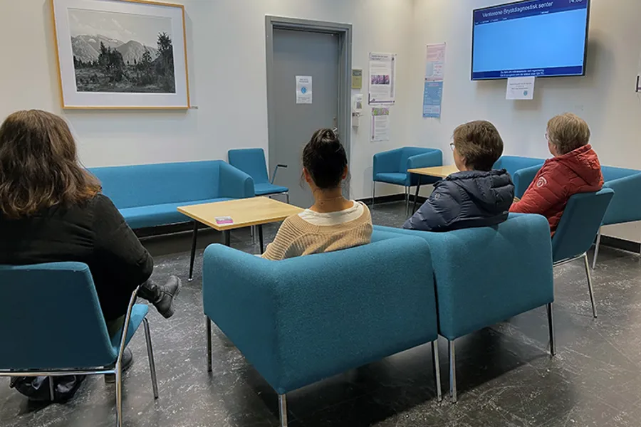 Ei gruppe menneske som sit i eit venterom