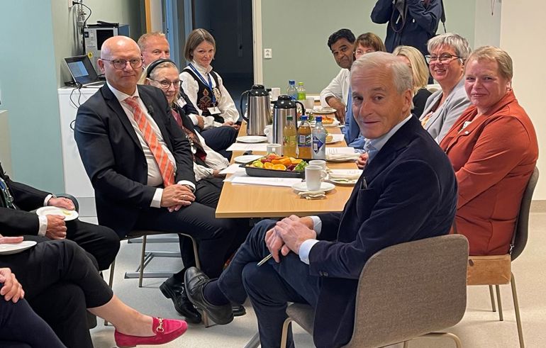 Ei gruppe mennesker som sit rundt eit bord