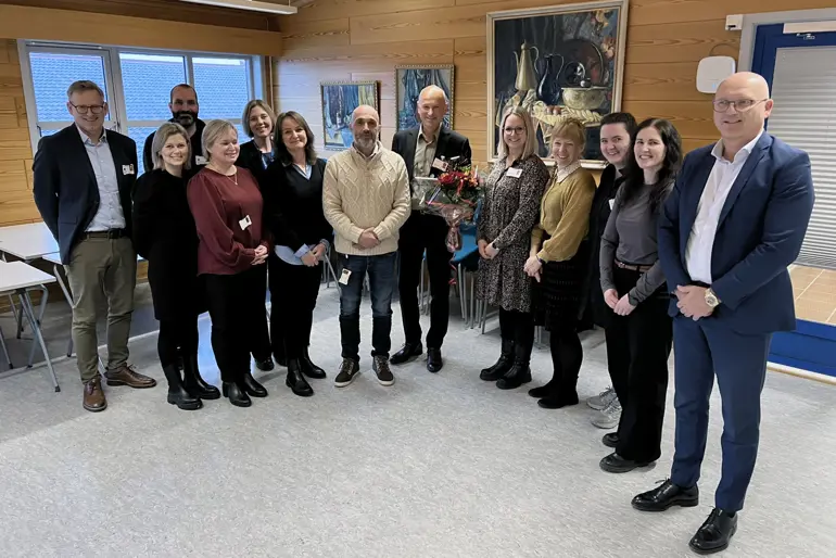 Prisvinnaren Trond F. Aarre omkransa av tilsette ved Nordfjord psykiatrisenter, og administrerande direktør Arve Varden.