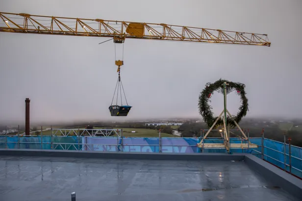 Bilde av en heisekran og en krans på toppen av Livabygget, under byggingen ved Førde sentralsykehus
