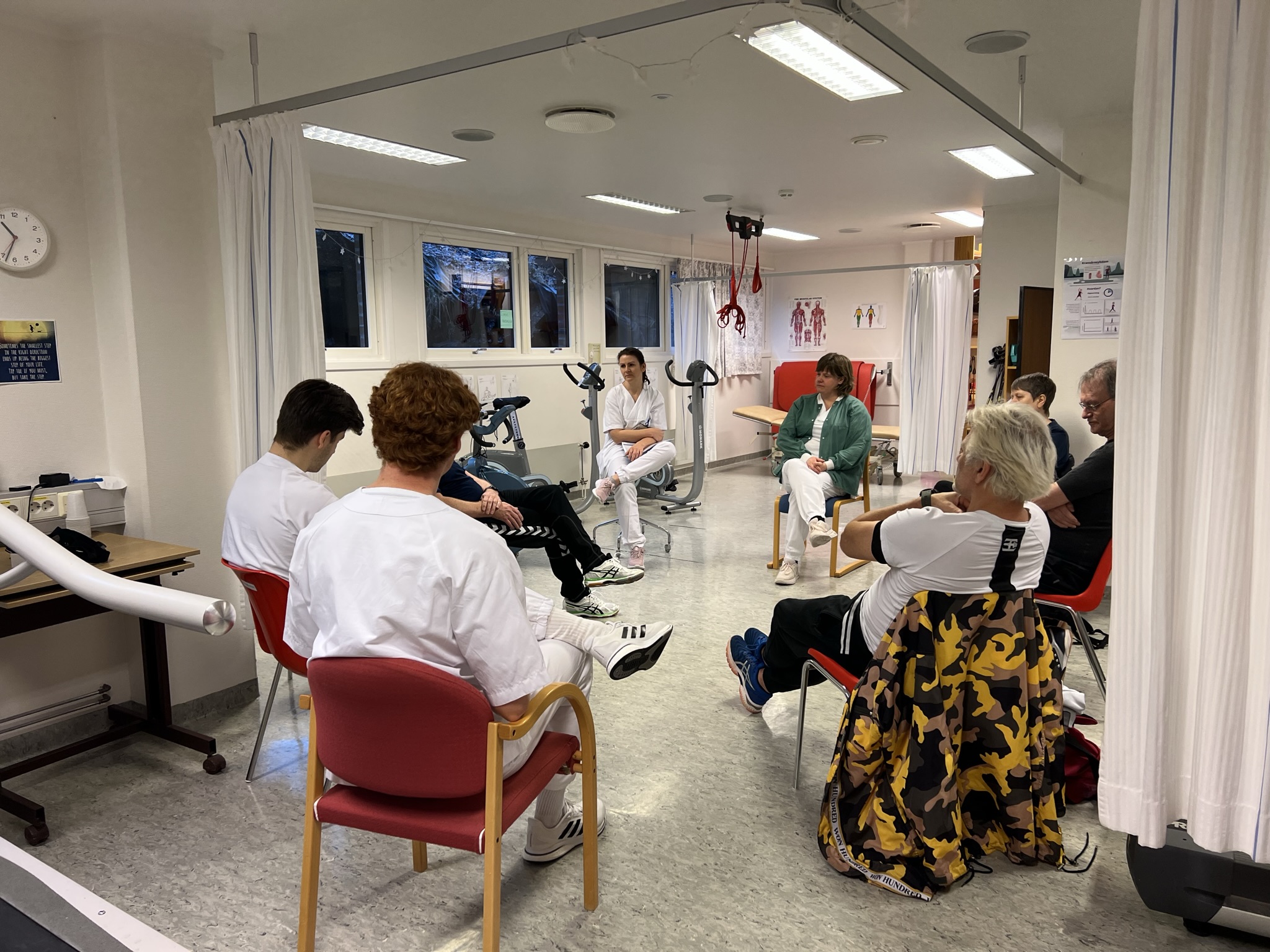 Ei gruppe pasientar og helsepersonell som sit i eit pasientkurs