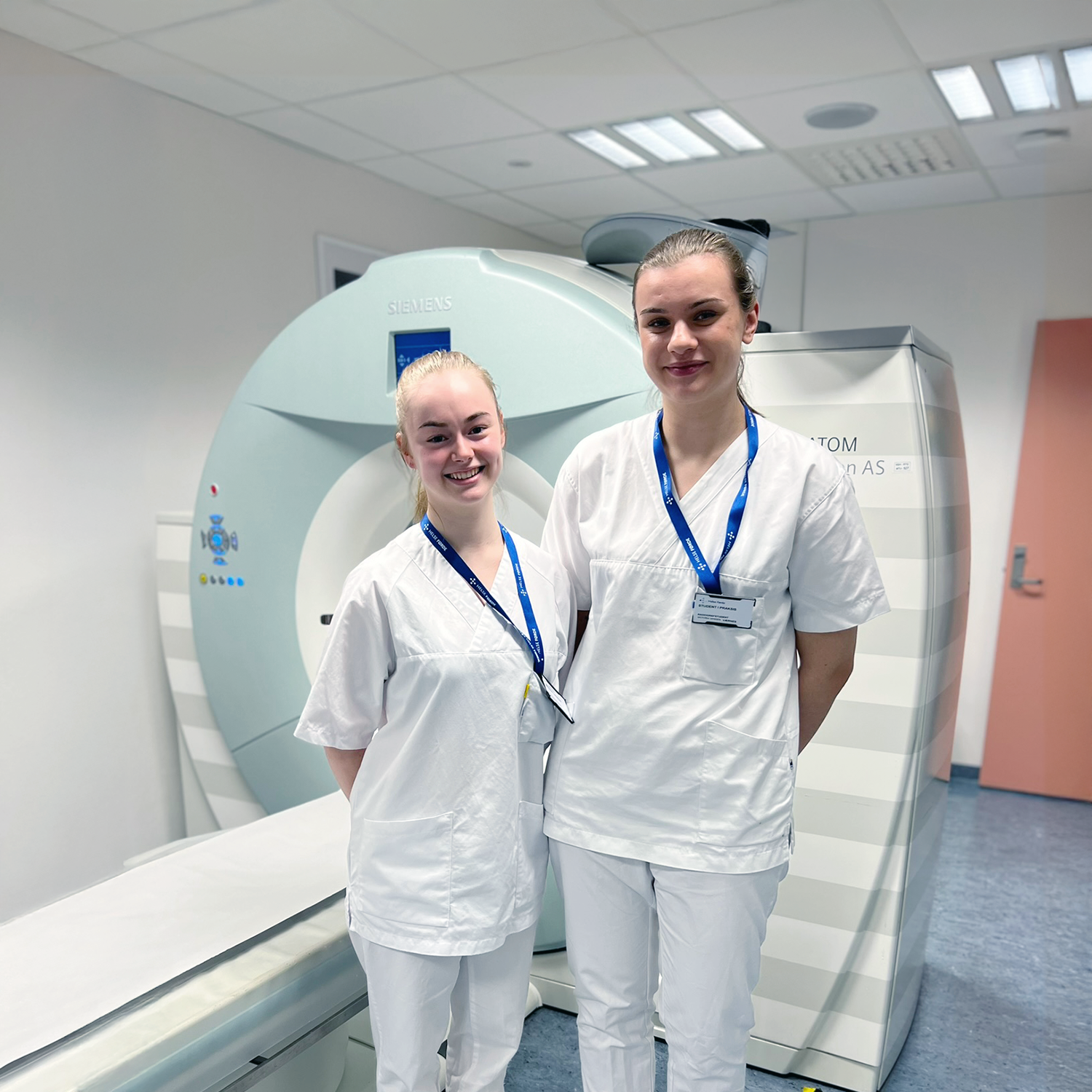 To happy girls in front of a ct-machine
