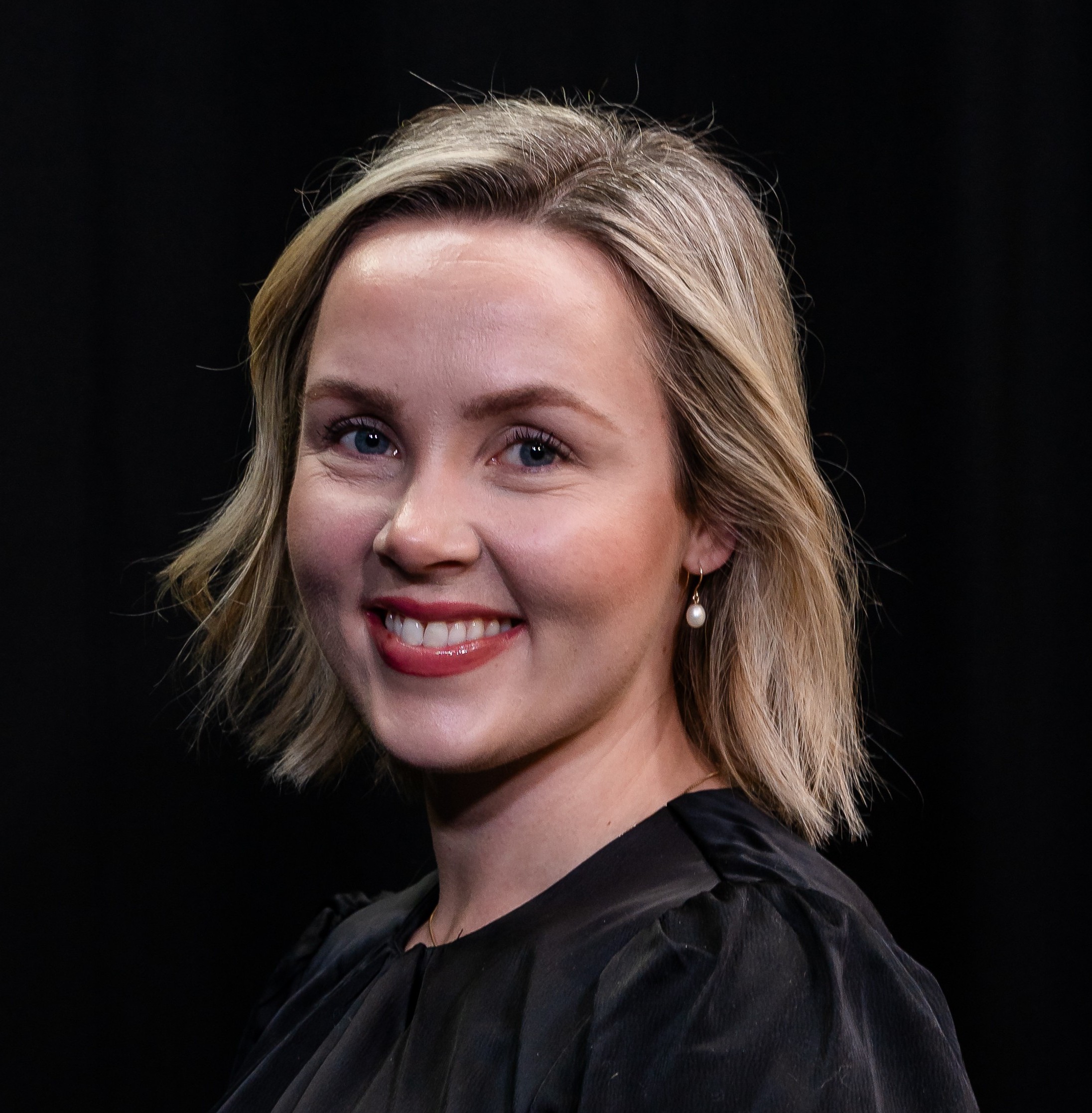 Portrettbilde av en smilende kvinne med blondt hår