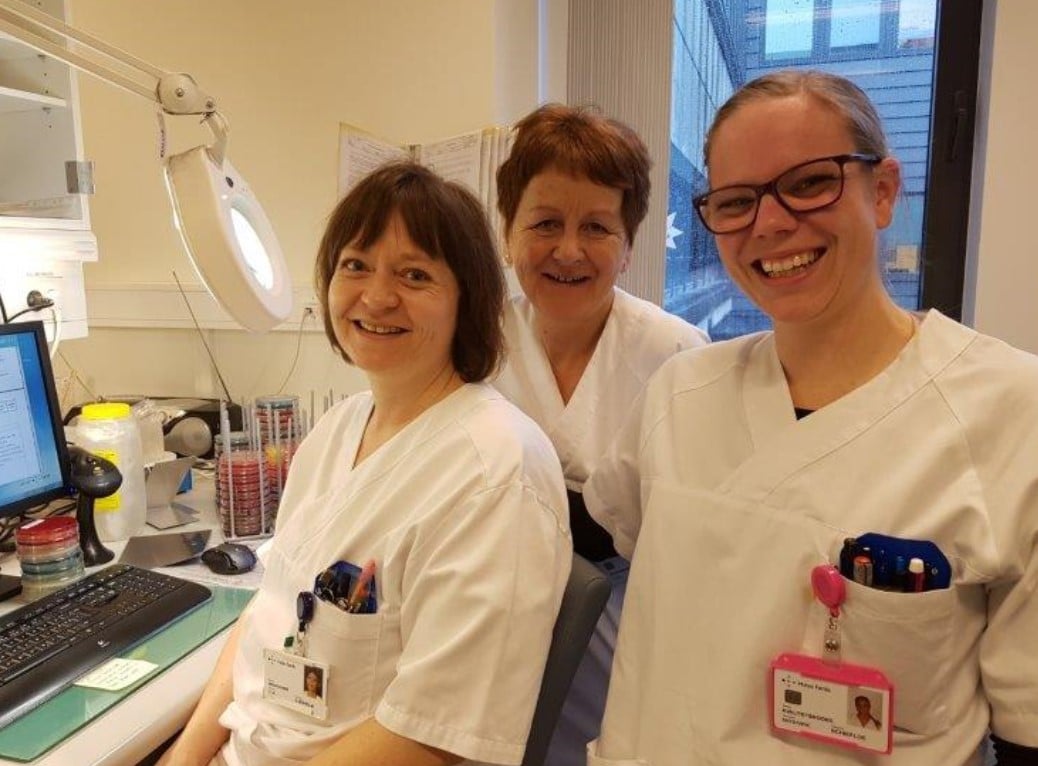 Tre kvinner i kvite laboratoriefrakkar