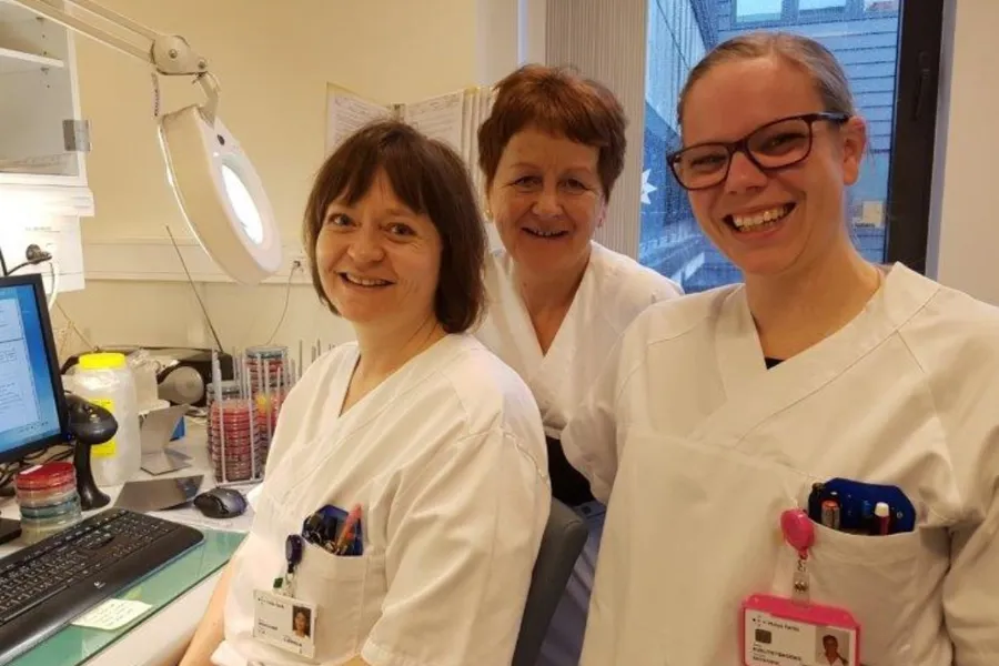 Tre kvinner i kvite laboratoriefrakkar