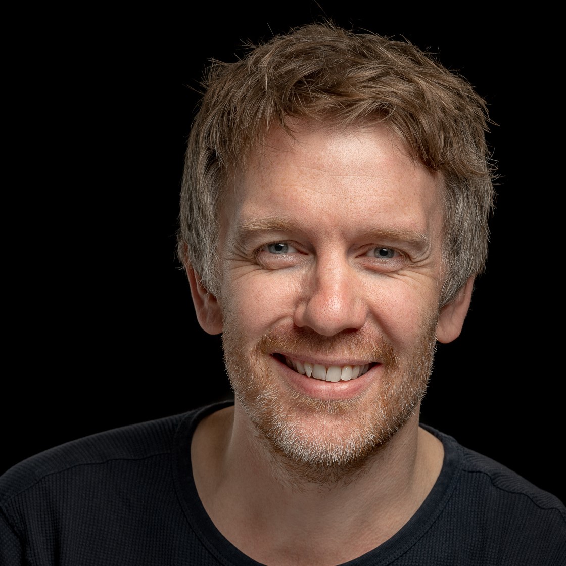 En mann som smiler til kameraet