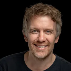 En mann som smiler til kameraet