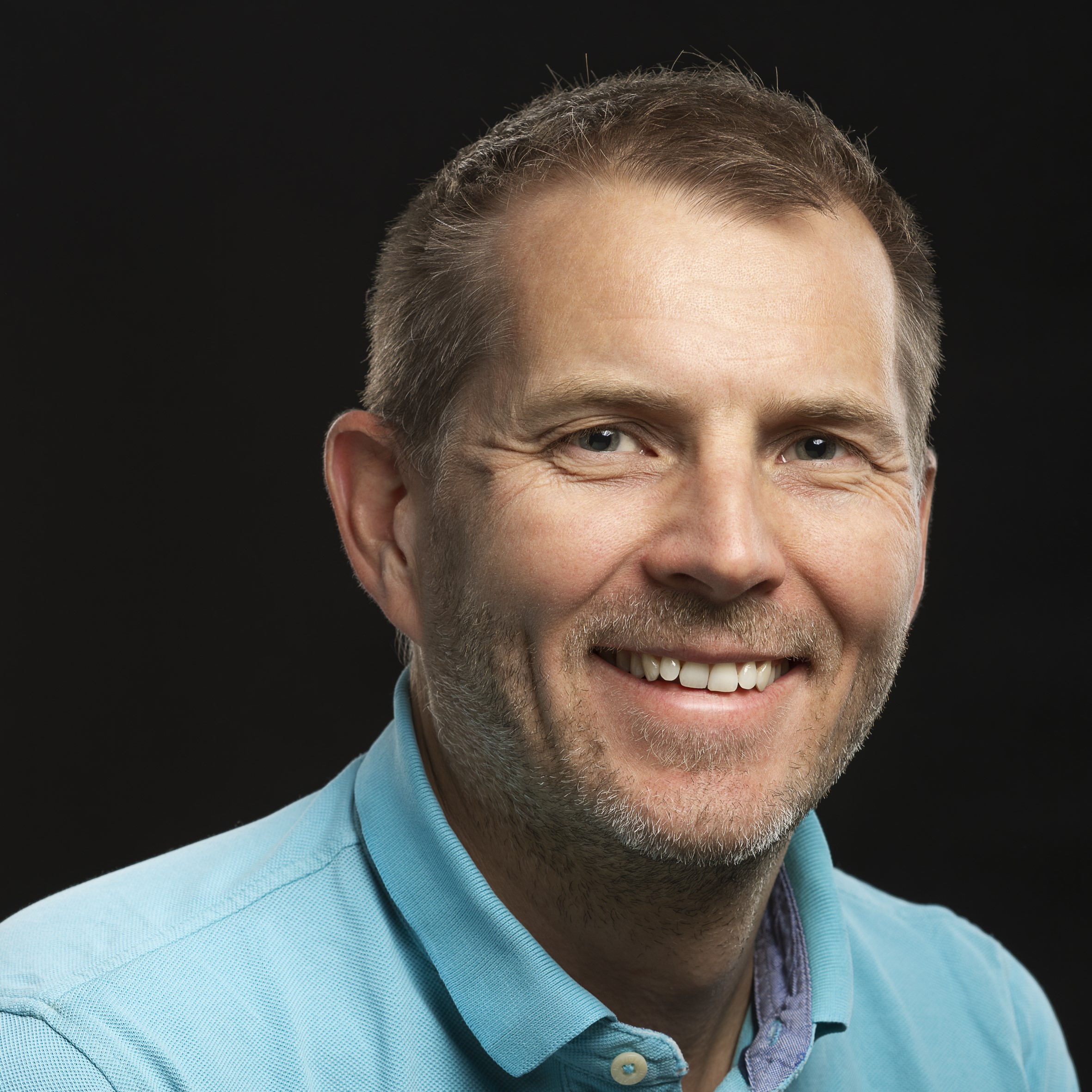 En mann som smiler til kameraet