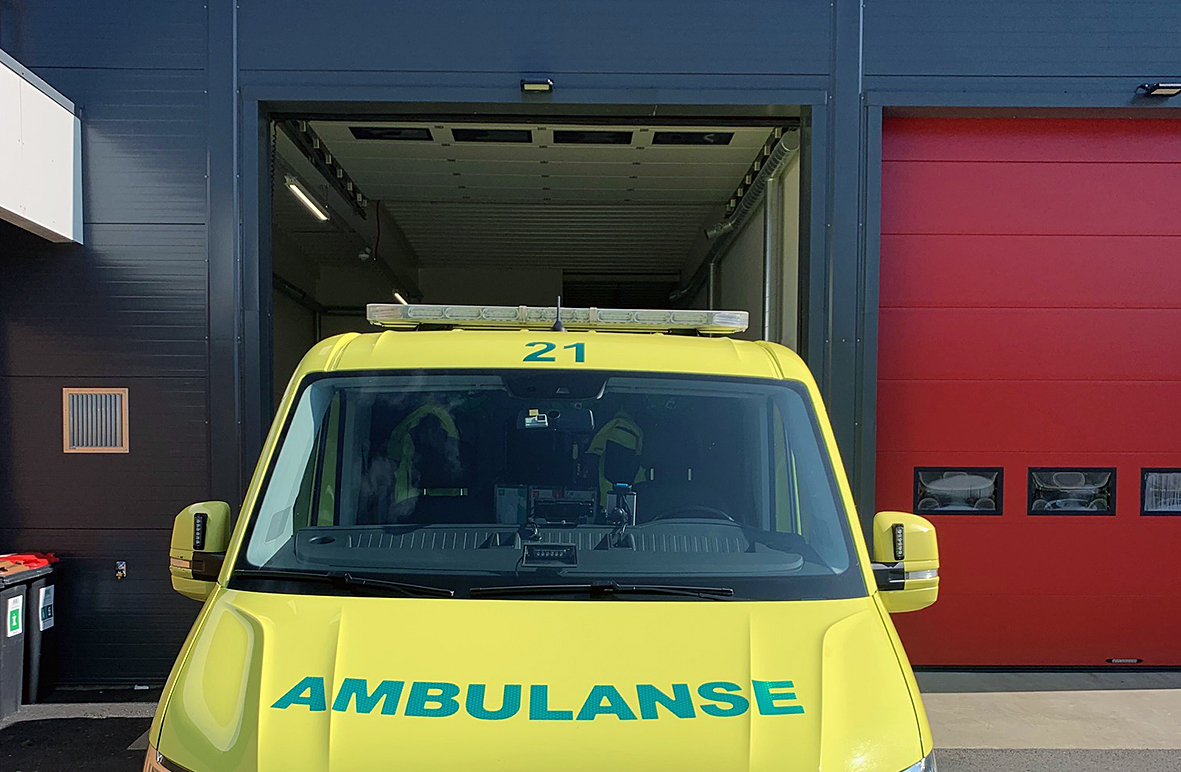 Ein ambulanse parkert framføre ein garasje