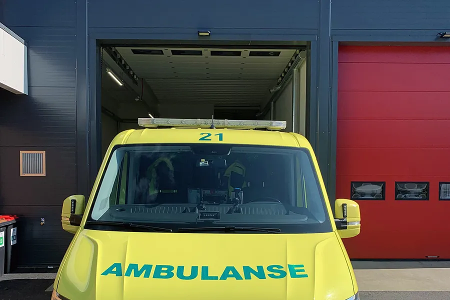 Ein ambulanse parkert framføre ein garasje