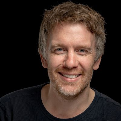 En mann som smiler til kameraet