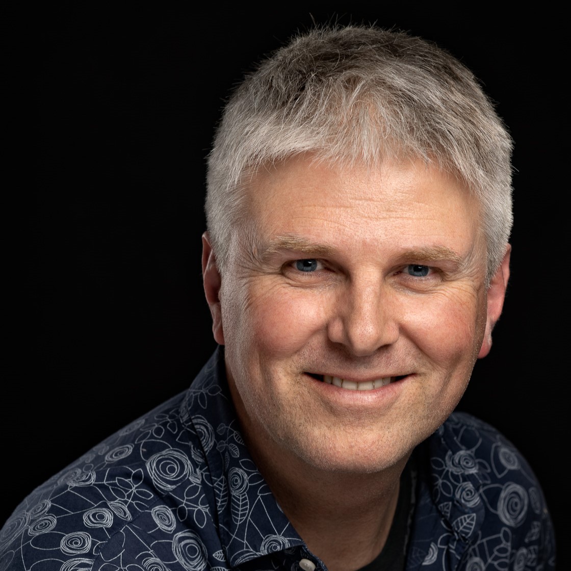 En mann som smiler til kameraet